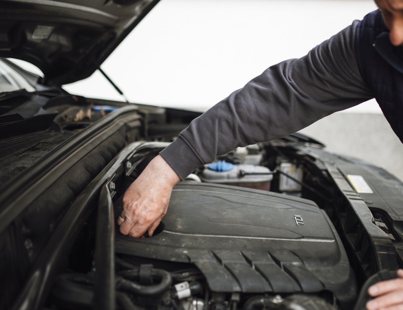A technician inspecting a vehicle's engine bay